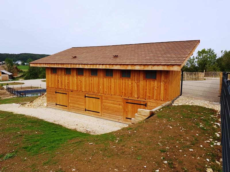 On voit ici l'arrière des toilettes sèches et ces 7 fenêtres carré et en dessous des toilettes on voit la grande chambre de compostage et ces 3 portes d'accès