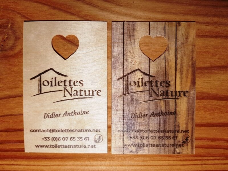 La photo represente mes deux nouvelles cartes avec un coeur découpé dedant, à gauche en bois brut, à droite avec une impression imitation vieux bois