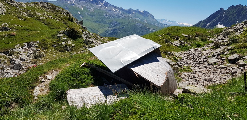 de la tôle et du bois devant un paysage de montagne